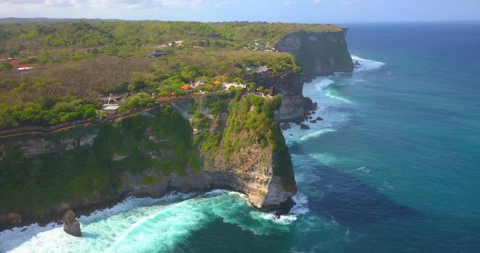 Pura Uluwatu temple. Stone cliffs, ocean waves and ocean landscape. Aerial view. Bali island, Indonesia.