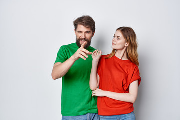 young couple in color t-shirts on a light isolated background