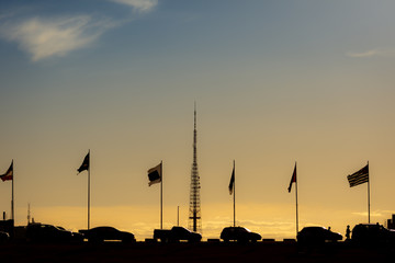 Brasilia, Brazil. July 2018. Alameda of the States, in front of the National Congress boasting all the flags of Brazil and its states during the sunset surrounded by tourists.