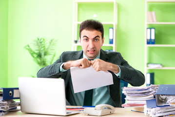 Naklejka premium Businessman angry with excessive work sitting in the office