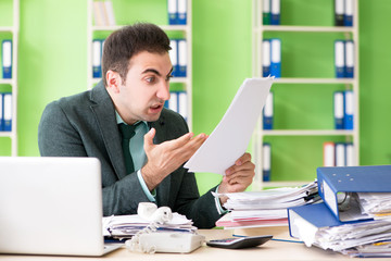 Fototapeta premium Businessman angry with excessive work sitting in the office