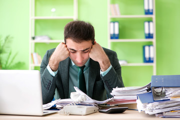 Fototapeta premium Businessman angry with excessive work sitting in the office