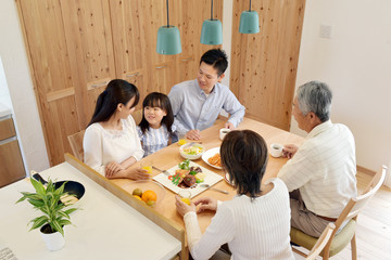 自宅で食事を楽しむ3世代家族