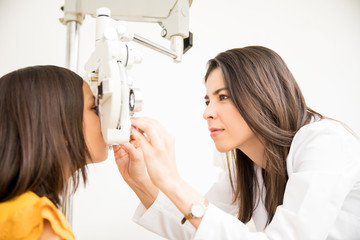 Optometrist doing sight testing for school girl patient