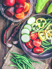 cut peppers, tomatoes and bean pods in a frying pan