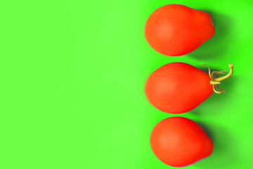 Obraz premium oval fruits of tomatoes on a green background