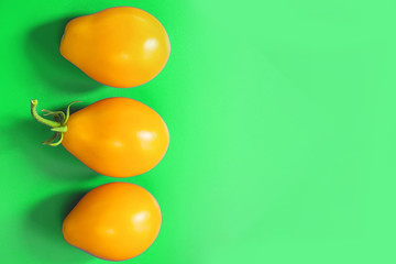 oval fruits of tomatoes on a green background