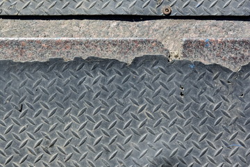 Ragged corrugated worn rubber coating on concrete steps.