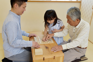 和室で将棋を楽しむ家族