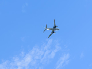 A modern aircraft flying high in the blue sky.