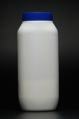 White plastic baby powder bottle isolated on black background