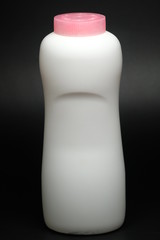 White plastic baby powder bottle isolated on black background
