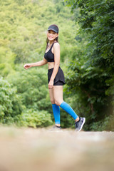 Asian woman were jogging on the road In the forest.wide angle copy space image.