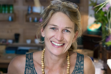 Portrait of a french blonde mature woman smiling at her store, entrepreneur concept.