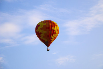 colorful hot air balloon against blue sky. hot air balloon is flying in white clouds. beautiful flying on hot air balloon