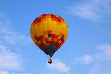 Naklejka premium colorful hot air balloon against blue sky. hot air balloon is flying in white clouds. beautiful flying on hot air balloon