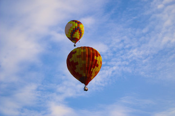 colorful hot air balloon against blue sky. hot air balloon is flying in white clouds. beautiful flying on hot air balloon