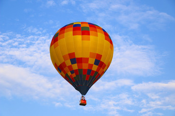 Naklejka premium colorful hot air balloon against blue sky. hot air balloon is flying in white clouds. beautiful flying on hot air balloon