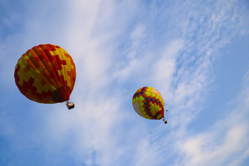 Fototapeta premium colorful hot air balloon against blue sky. hot air balloon is flying in white clouds. beautiful flying on hot air balloon