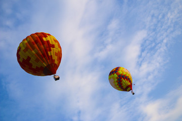 colorful hot air balloon against blue sky. hot air balloon is flying in white clouds. beautiful flying on hot air balloon