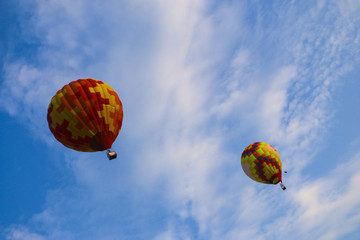 colorful hot air balloon against blue sky. hot air balloon is flying in white clouds. beautiful flying on hot air balloon
