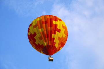 colorful hot air balloon against blue sky. hot air balloon is flying in white clouds. beautiful flying on hot air balloon