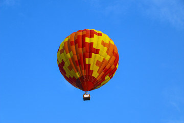 colorful hot air balloon against blue sky. hot air balloon is flying in white clouds. beautiful flying on hot air balloon