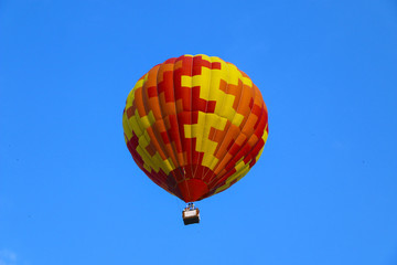 Fototapeta na wymiar colorful hot air balloon against blue sky. hot air balloon is flying in white clouds. beautiful flying on hot air balloon