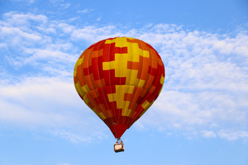 colorful hot air balloon against blue sky. hot air balloon is flying in white clouds. beautiful flying on hot air balloon