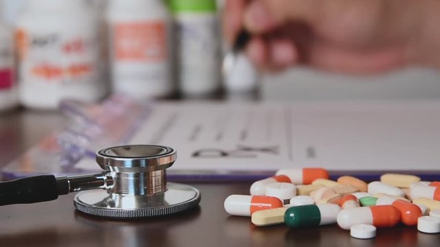 Male doctor hands writing rx prescription.