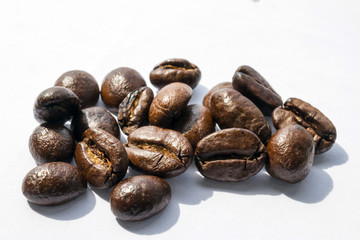 Macro shot of coffee beans pile on white.