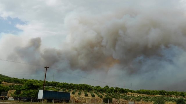During the wildfires in Attica Greece. View of the smoke from the highway and Skycrane helicopter firefighting.