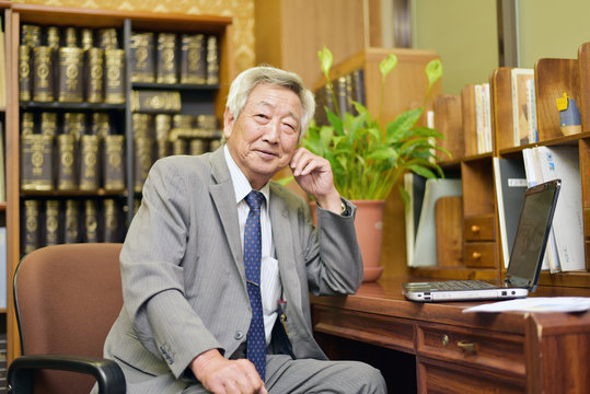 重役室で微笑むシニアビジネスマン