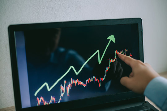 Business man look at to the notebook show financial market chart graphic going up. Bull market, Stock market concept.