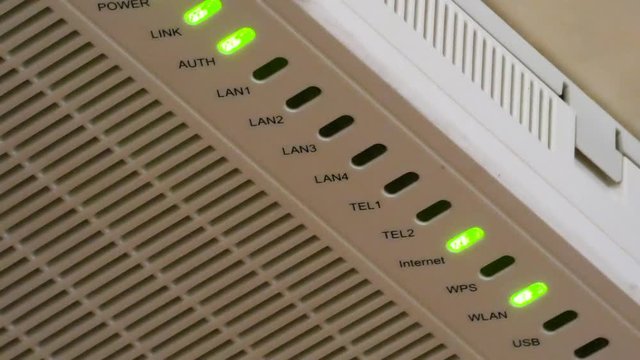 Green LED lights flashing on router. Internet and local network connection. Electronic device closeup view.