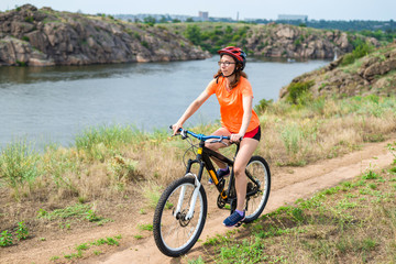 Fototapeta premium Young woman riding a mountain bike, an active lifestyle.
