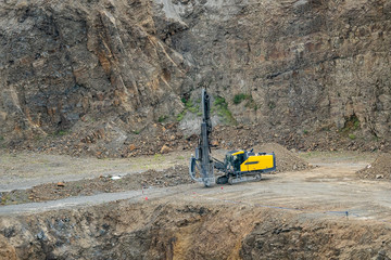 Opencast mining quarry with mining drilling machine. Mining in the granite quarry. Mining industry.