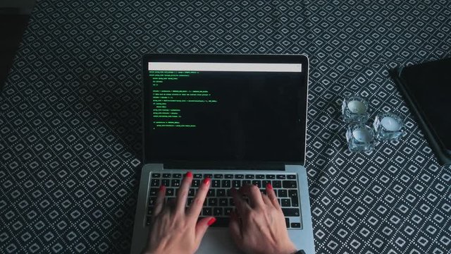 Woman coding on a computer and hacking a terminal on a laptop