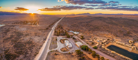 Rural road leading to the horizon at sunset - aerial view