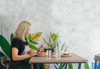 Beautiful young lady alone in restaurant.
