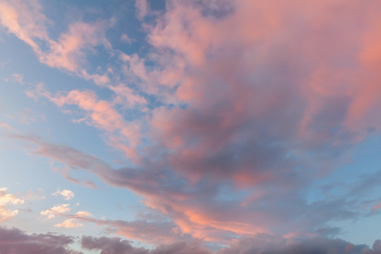 Beautiful clouds and blue sky background at sunset with pink and purple tones over England UK. Cloudscape and skyscape backdrop 0162