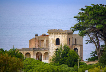 Fototapeta premium An old derelict castle sits high on a hill top overlooking the sea