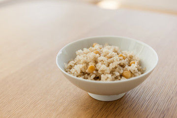 brown rice on the bowl, wood table.