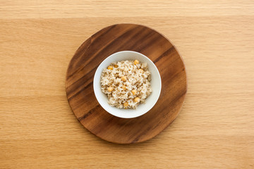 brown rice on the bowl, wood table.