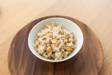 brown rice on the bowl, wood table.
