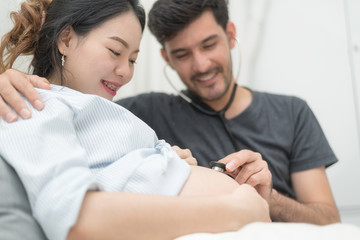 Fototapeta premium In Selective Focus Of Happy Family Checking New Baby In The Morning.Close Up Of A Beautiful Happy Pregnant Woman With Big Belly. Pregnancy And Motherhood Moment People And Expectation Concept.