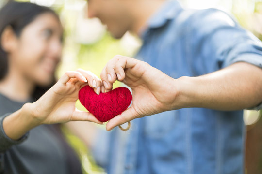 Two hand holding Red Heart overy blurred of Lover Young Couple Anniversary Celebration Party Together on valentine's day.
