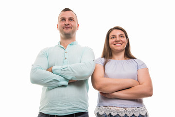 Low angle of young happy couple standing with arms crossed