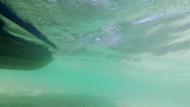 A clip of moving speedboat viewed from the side and underwater in slow motion