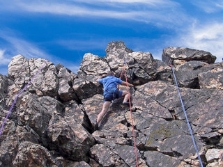 man climbing up a rock